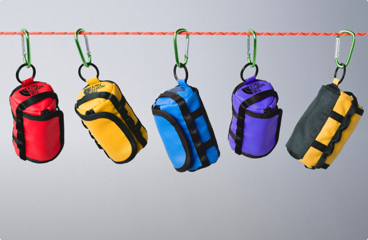 Mini duffel keychains hanging on a rope on a carabiner.