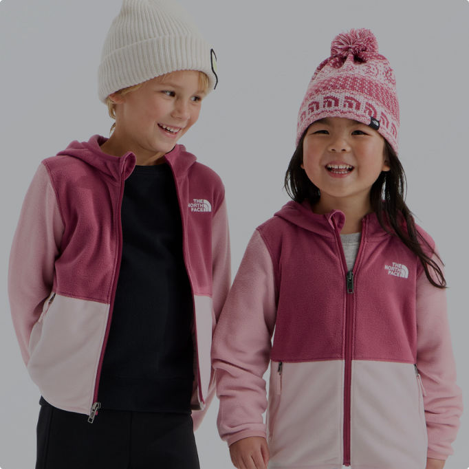 A little girl and little boy wearing pink fleeces from The North Face.