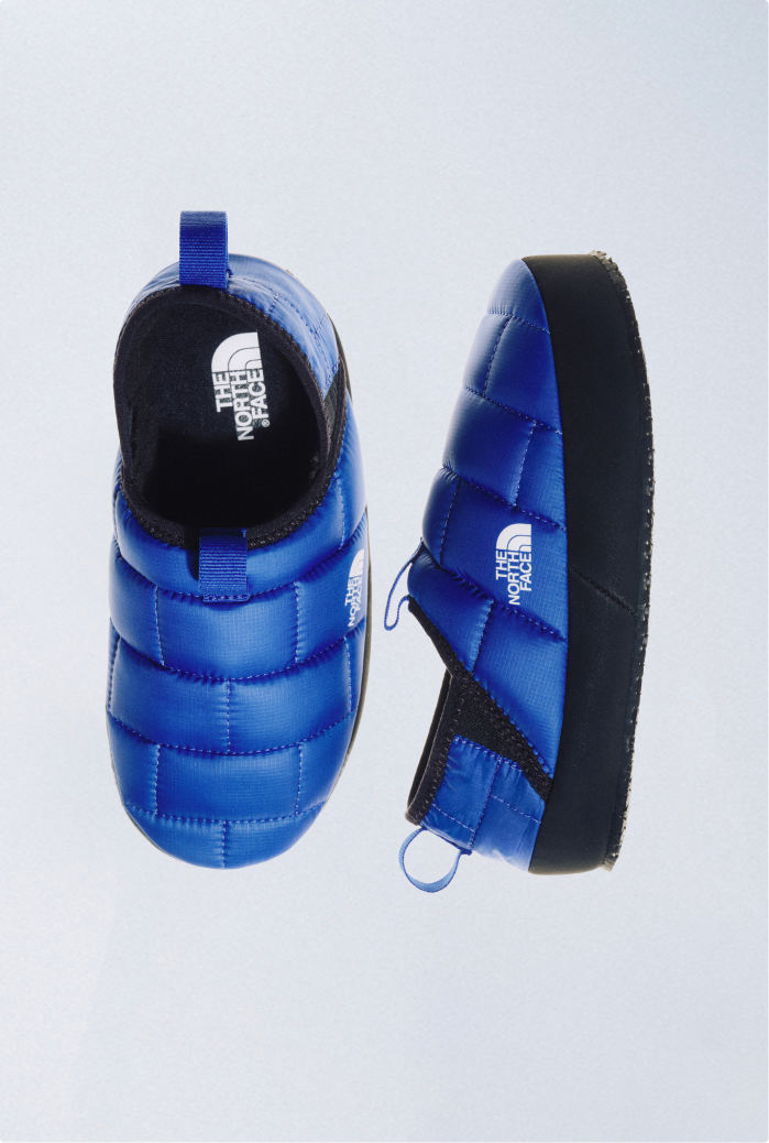 Lay-flat of blue/black Thermoball mules from top view and side view, side by side.