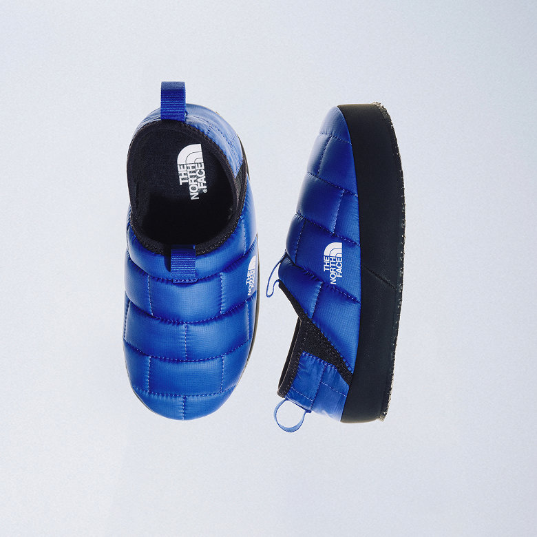 Lay-flat of blue/black Thermoball mules from top view and side view, side by side.