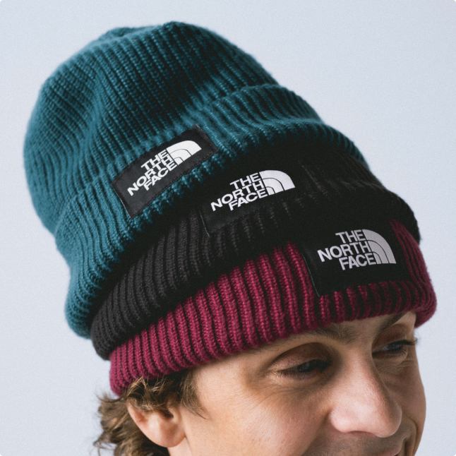 A man wearing three beanies on his head.