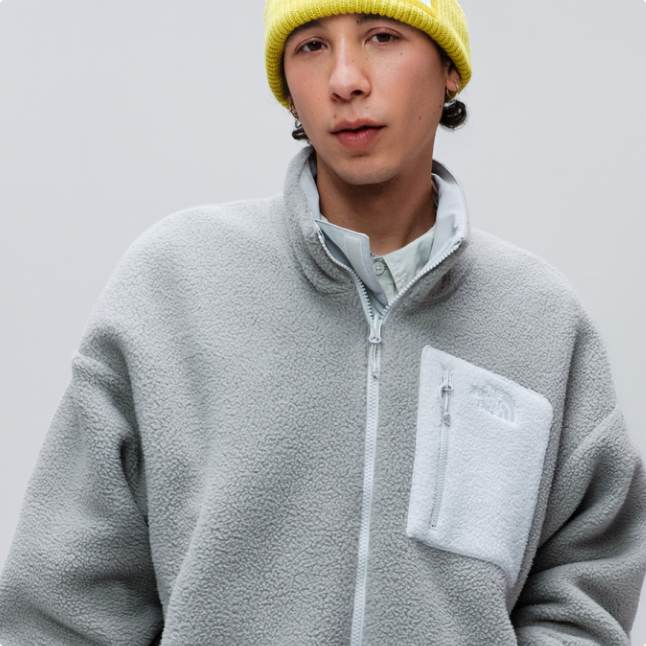 A man wearing a light grey reversible Yumiori fleece and a yellow beanie.