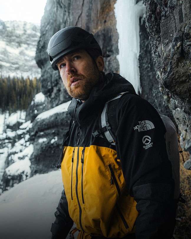 Man in Gold Summit Series Climbing Gear next to a frozen waterfall.