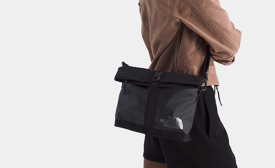 A studio shot of someone carrying a Base Camp Shoulder Bag.