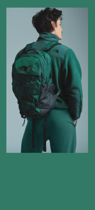 A man in a matching green Borealis and fleece, the image has a green frame around it.