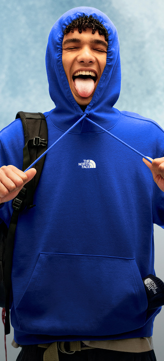 Young man wearing a blue sweatshirt with hood pulled on and draw strings pulled.