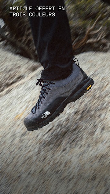 Des jambes en mouvement d’une personne portant des chaussures d’approche Verto noires sur une surface rocheuse. 