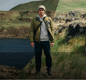 Man in a green jacket overlooking a lake.