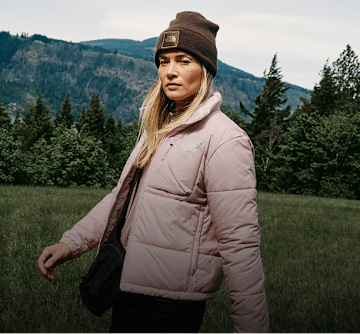 Woman in pink jacket standing in the woods