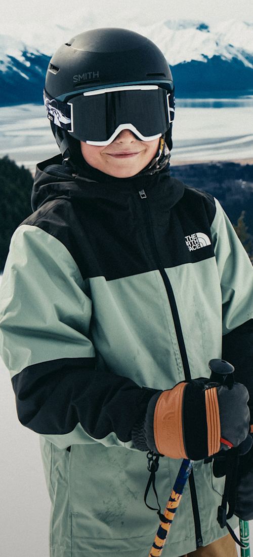 A snowboarder wearing The North Face Men’s Chakal Jacket in Dusk Blue/TNF Black.