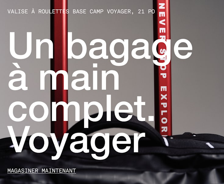 he top of black rolling luggage, you can read “NEVER STOP EXPLORING” on the handle.