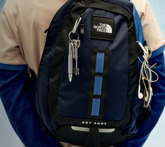 Gros plan d’un sac à dos Hot Shot noir porté par une jeune personne. 