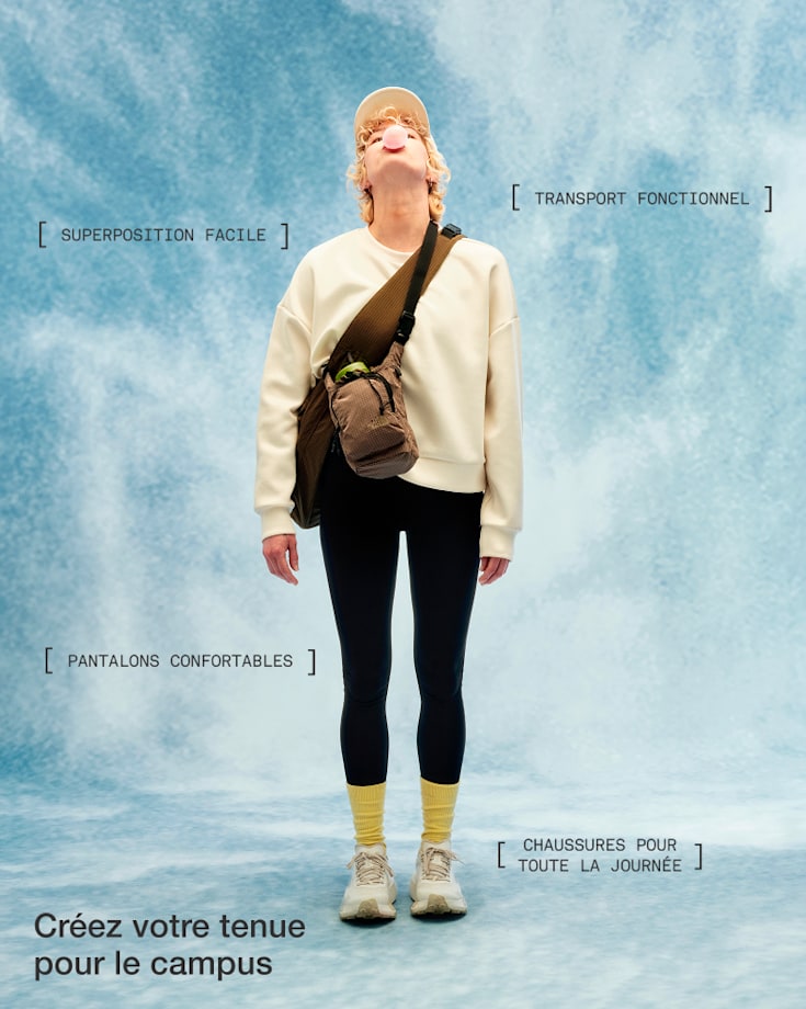 Une personne vêtue d’un chandail molletonné blanc cassé, d’un pantalon noir, de chaussettes jaunes et de chaussures blanches, portant un sac à bandoulière brun, qui regarde vers le haut et fait une bulle avec sa gomme à mâcher.