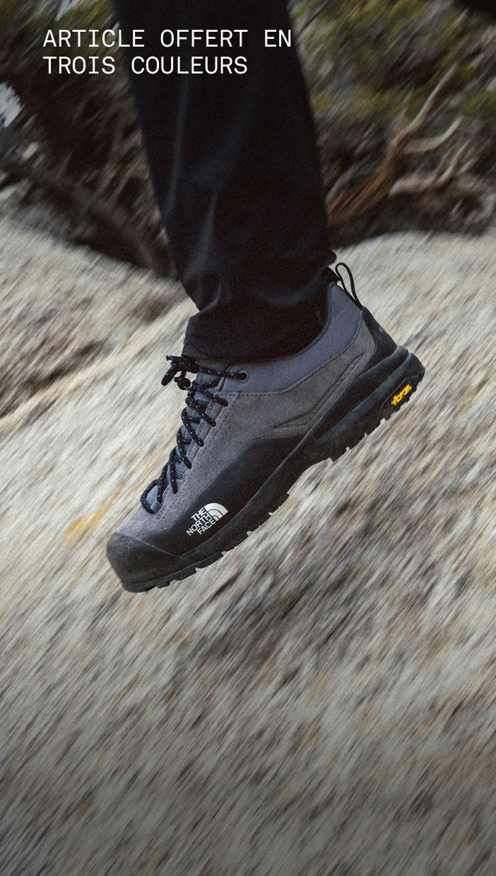Des jambes en mouvement d’une personne portant des chaussures d’approche Verto noires sur une surface rocheuse. 