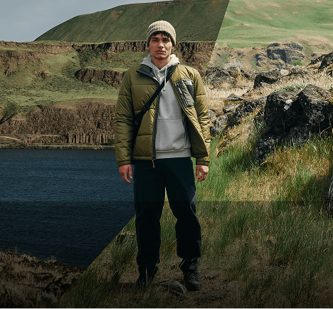 Man in a green jacket overlooking a lake.