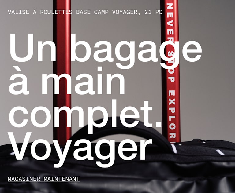 he top of black rolling luggage, you can read “NEVER STOP EXPLORING” on the handle.