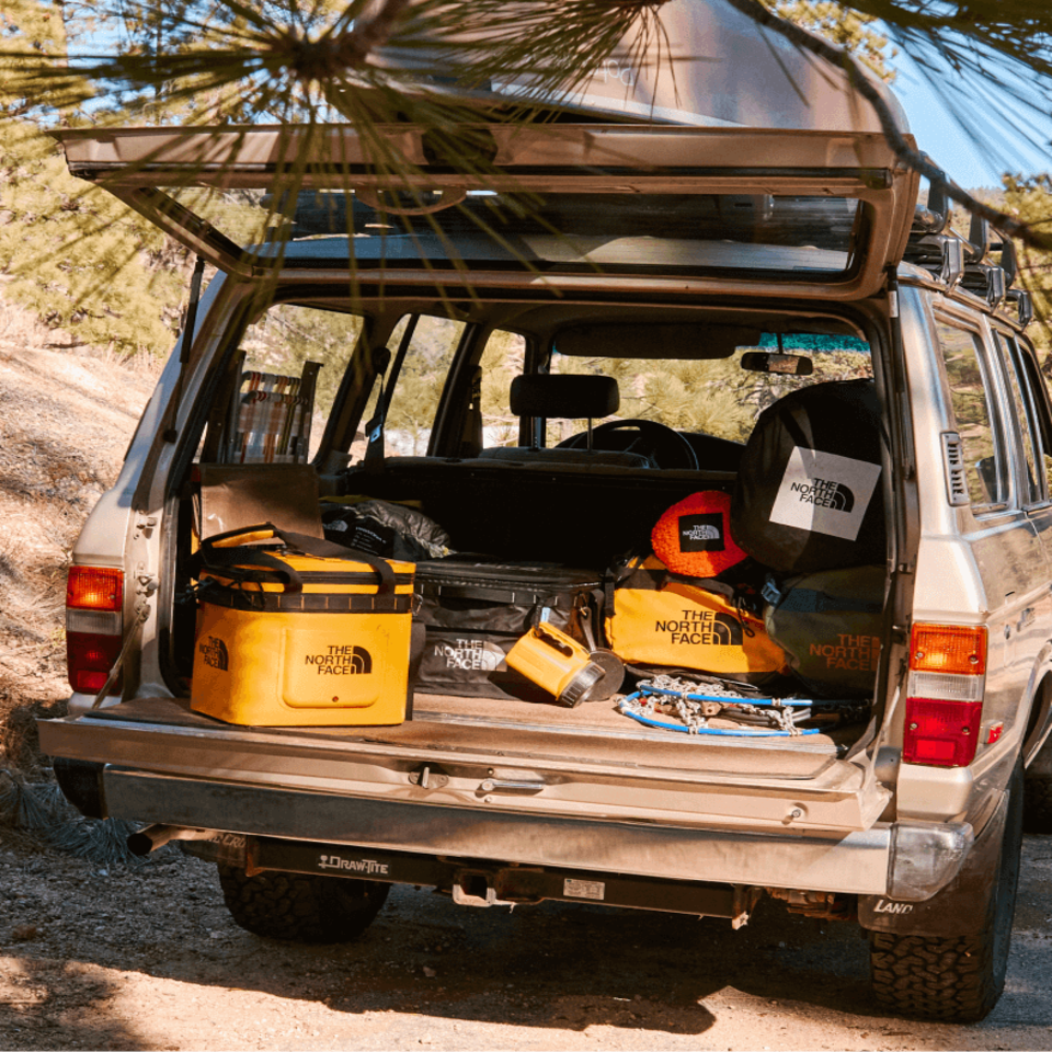 open trunk of a car full of travel accessories from The North Face. 