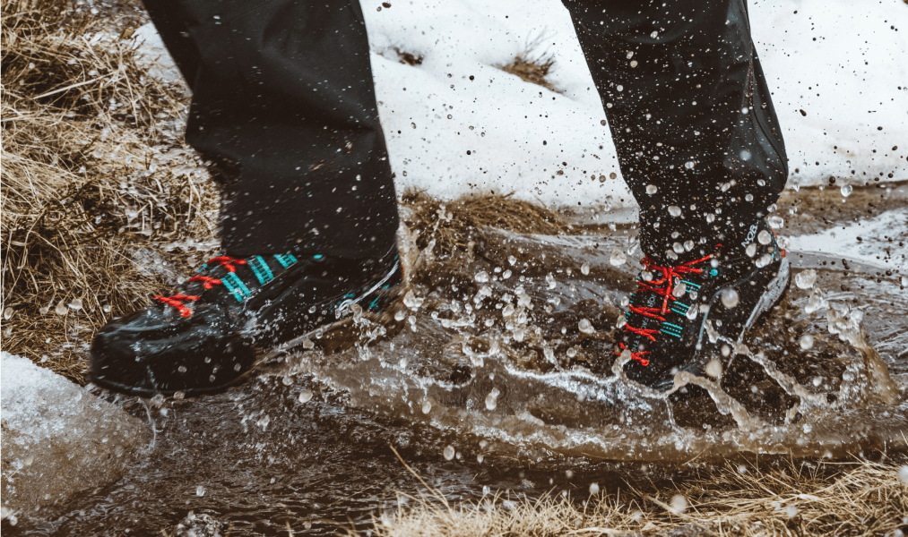 image of hiking boots keeping feet dry while walking through and icy puddle of water