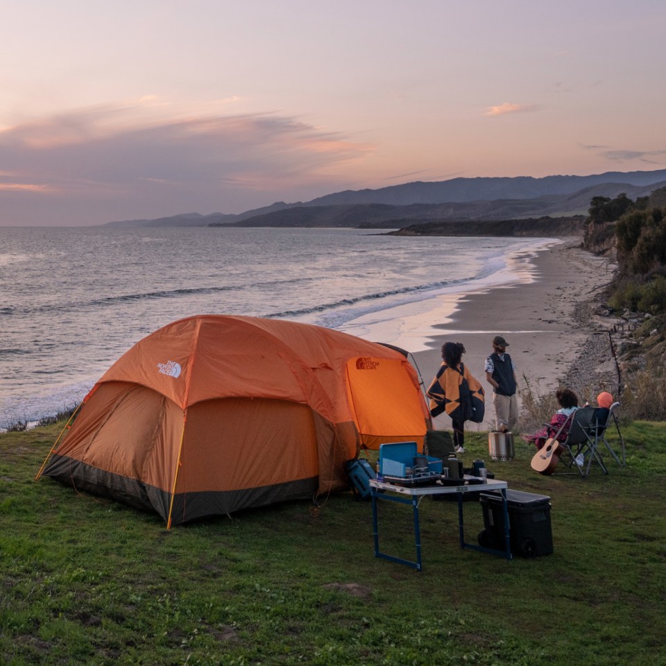 image of a wawona 6 on a grassy cliff overlooking the beach and a sunset