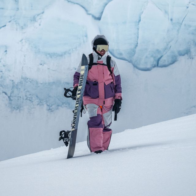 Photo of a snowboarder in gear from The North Face walking on a snowy mountain