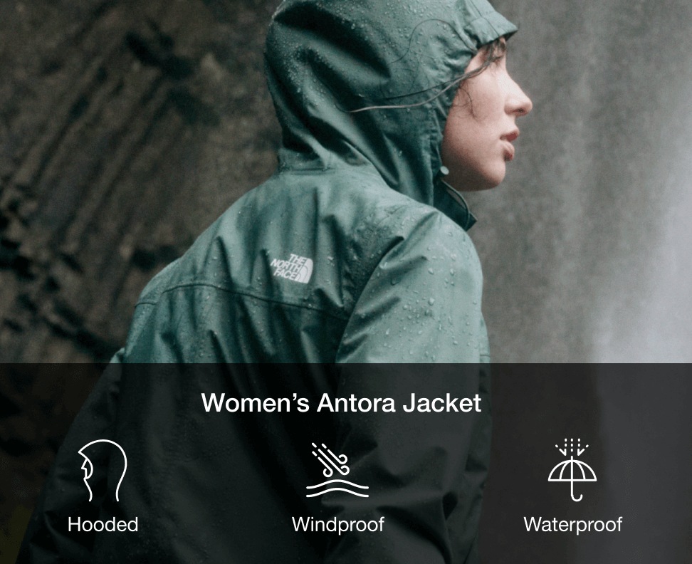 A woman in a green rain jacket with the hood up looking to the left. 