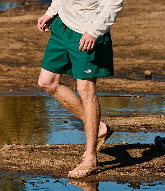 A man walks through a puddle wearing shorts from The North Face