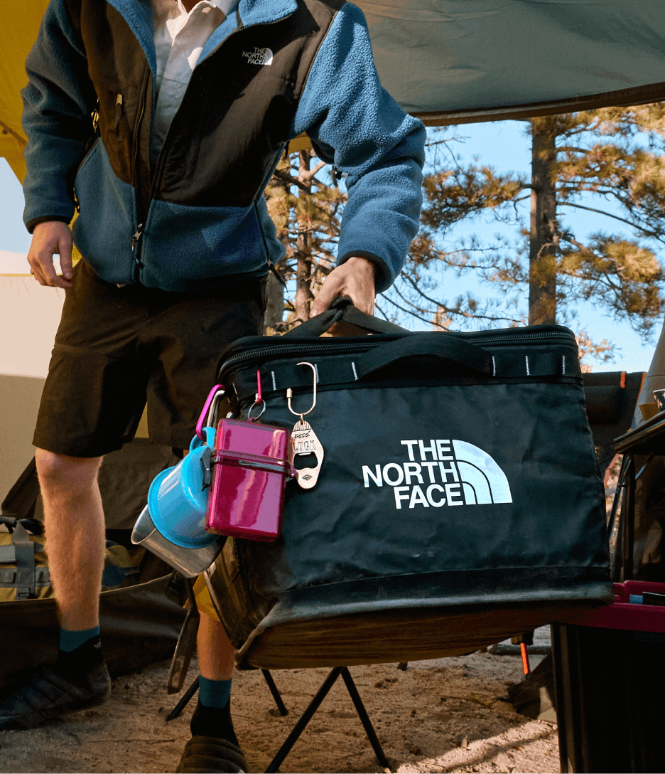 A person carrying a black gear box from The North Face