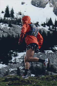 A close up of a person’s legs, they’re wearing black socks and Vectov shoes and running to the left.