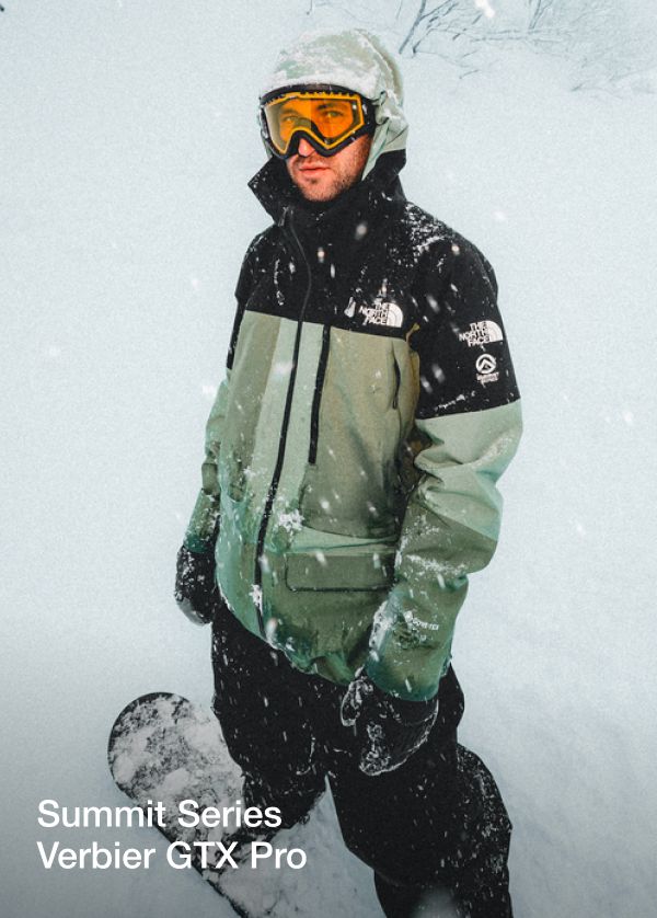 Image of The North Face athlete Nik Baden standing in a snow storm on his snowboard.