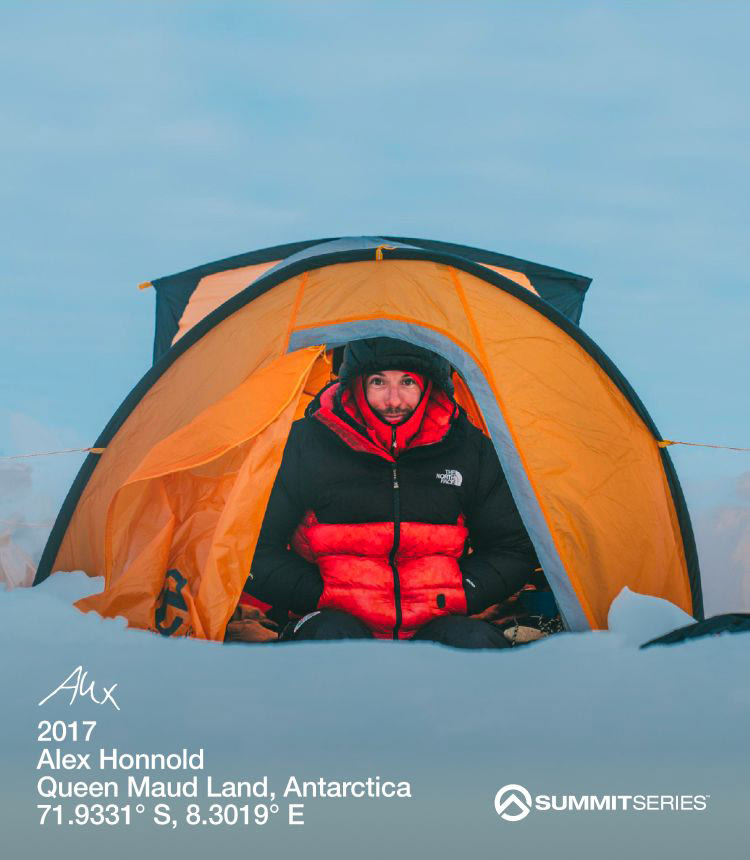 Alex Honnald in a red and black jacket sitting in a yellow tent surrounded by snow.
