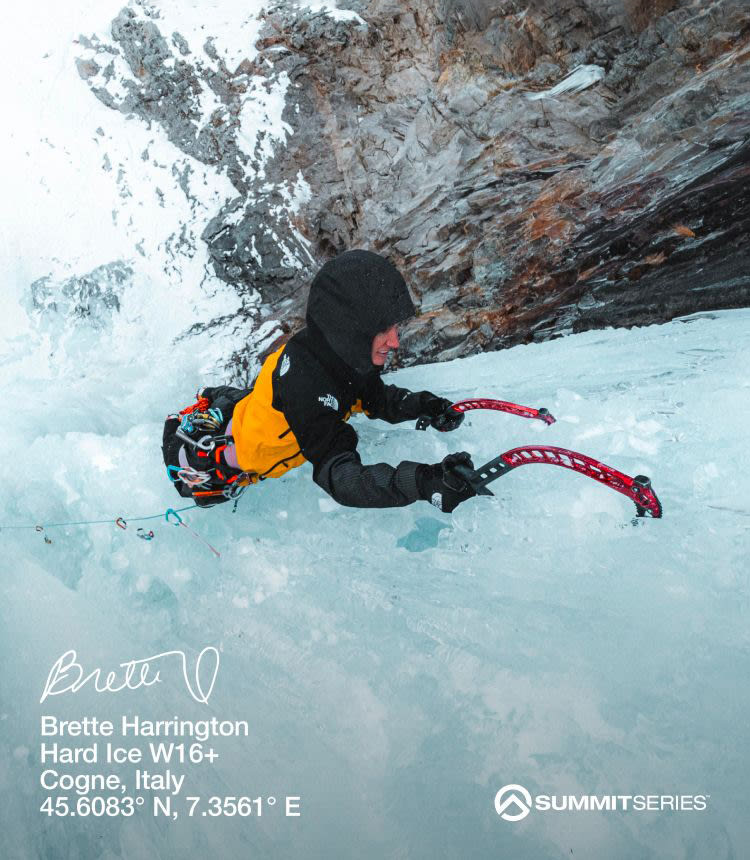 Overhead view of ice climber in a yellow and black jacket ascending a wall of ice with picks. 