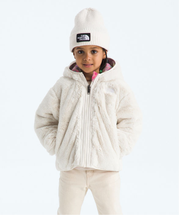 A small child walking in a puffy one piece from The North Face.