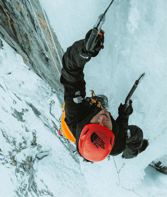 A woman climbing with an ice axe.