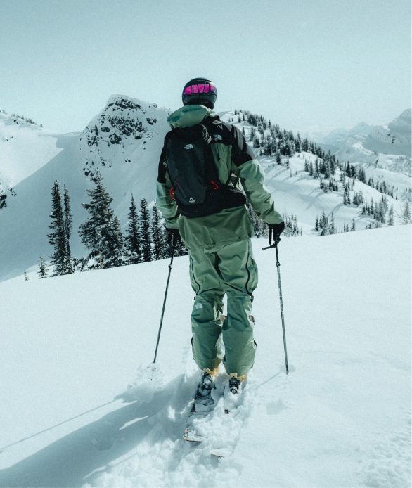 A woman in black socks and tan ankle-height hiking shoes pushing herself up rocks. The shoe is the focal point.