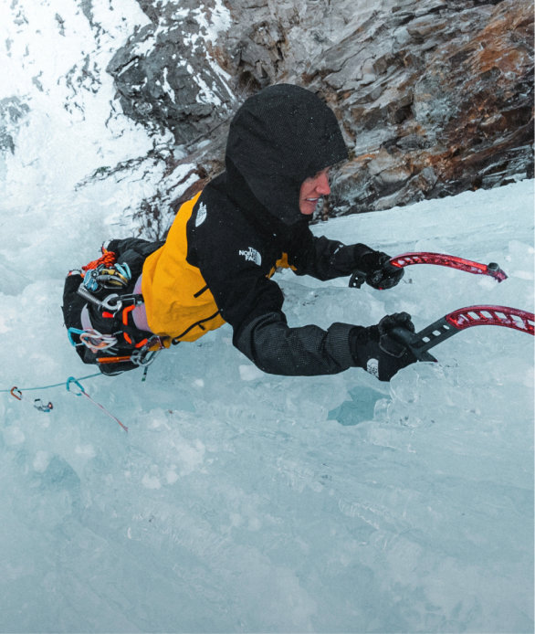 A woman climbing with an ice axe.