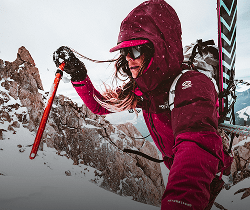 A woman in the AMK suit hiking in the snow.