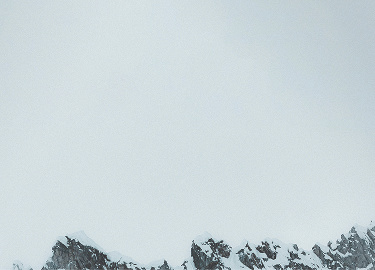 A snowy ridge with gray sky in the background.