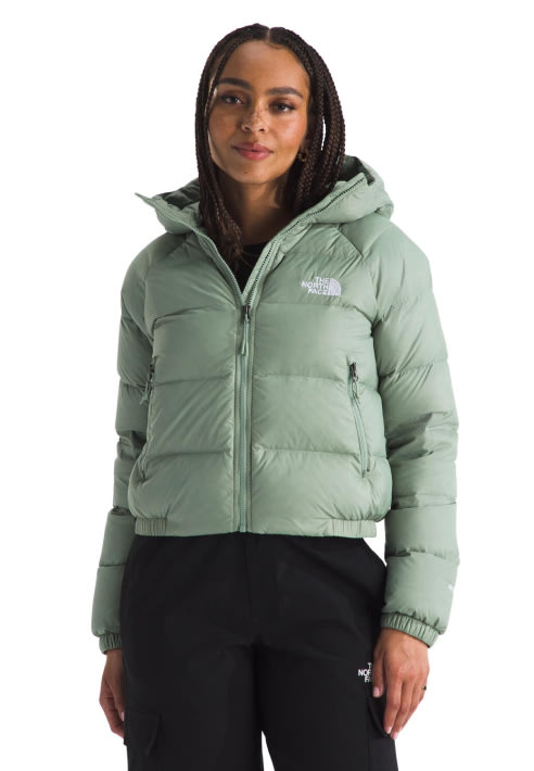 A woman in a light green Hydrenalite Down Hoodie and black pants.