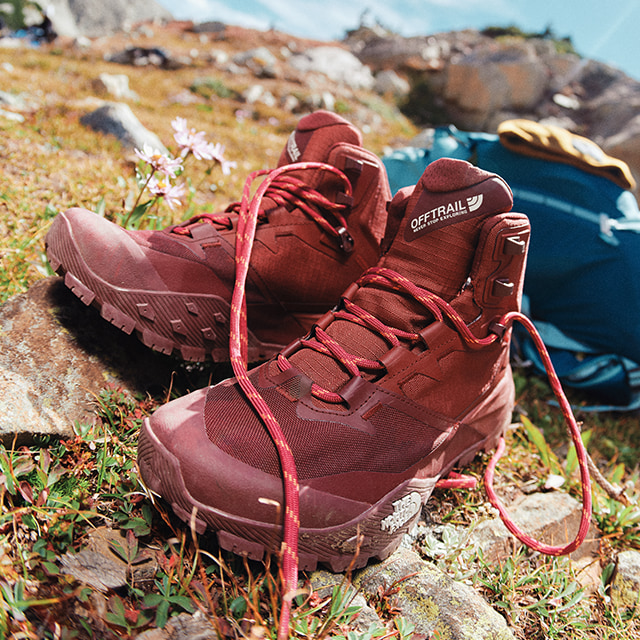 red hiking boots placed on a tundra