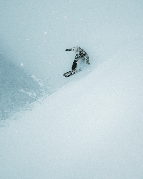Image of a snowboarder wearing The North Face, traversing down a snowy mountain.