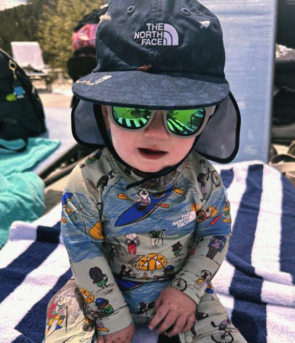 Image of a baby wearing a sun hat and water onsie from The North Face.